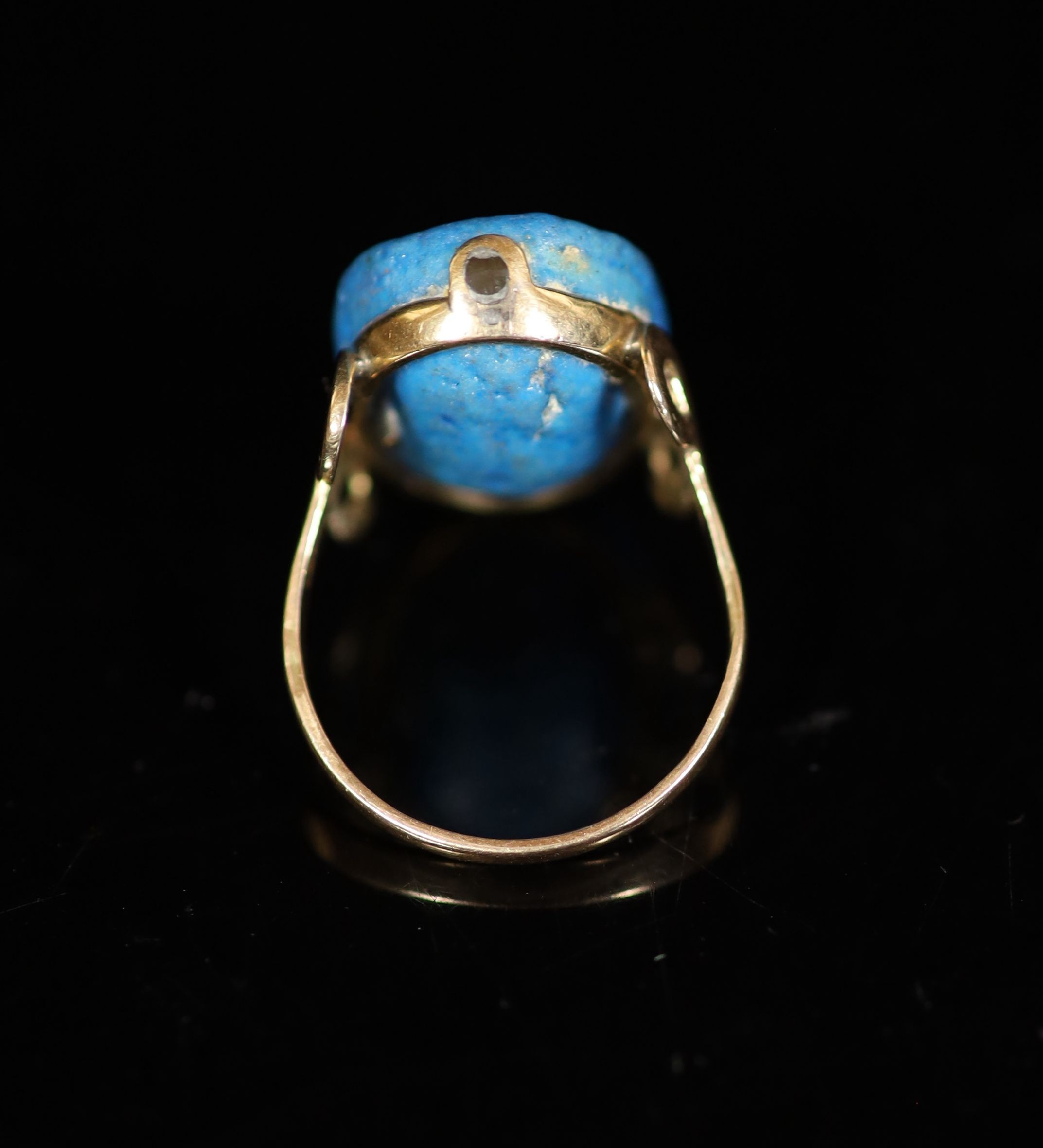 An antique gold and oval turquoise glazed intaglio set ring